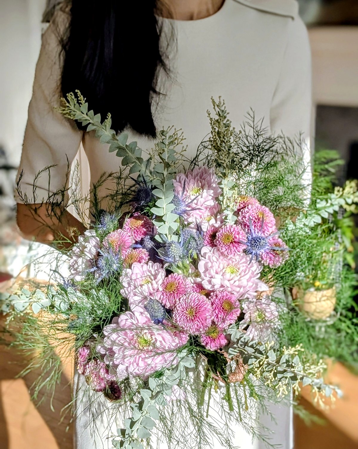 Hand-tied bouquet — pink chrysanthemums, sea holly, and feathery foliage